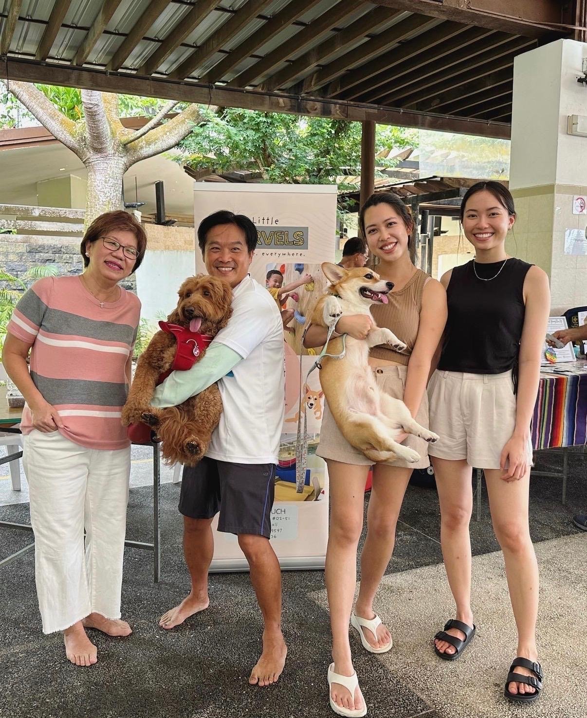 The Little Marvels team with therapy dogs at a Grace Mission autism acceptance booth with Member of Parliament Dennis Phua