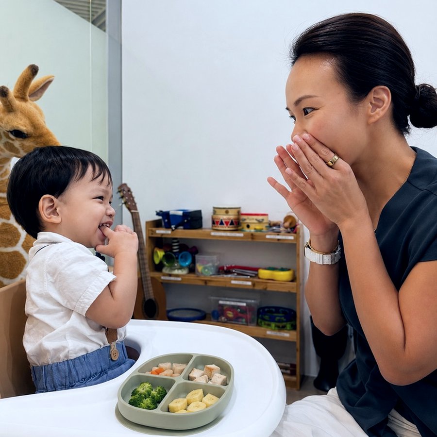 A speech therapist supporting a toddler during a feeding and communication session
