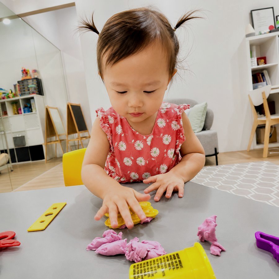 A toddler engaged in sensory play with playdough